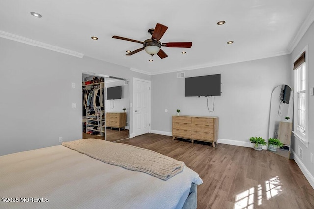 bedroom with recessed lighting, baseboards, wood finished floors, and crown molding