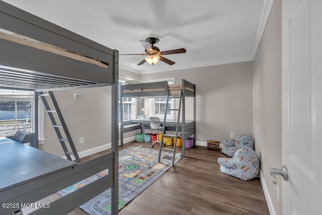 bedroom with crown molding, wood finished floors, and baseboards