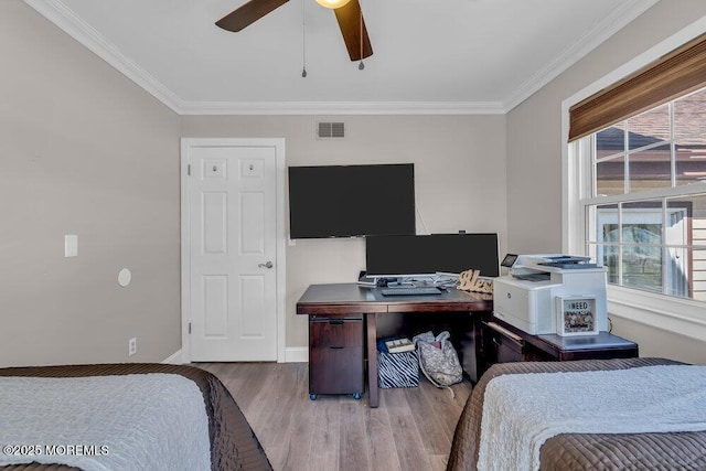 bedroom with visible vents, multiple windows, wood finished floors, and crown molding