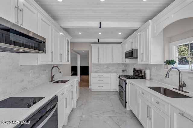 kitchen with white cabinetry, stainless steel appliances, marble finish floor, and a sink