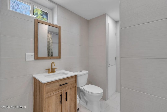 bathroom featuring toilet, curtained shower, tile walls, and vanity