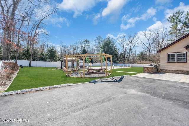 view of yard featuring fence and a pergola