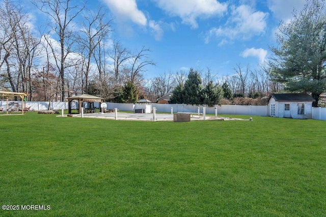 view of yard featuring a gazebo, an outdoor structure, and a fenced backyard