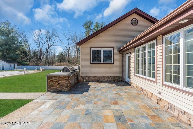 view of patio / terrace with area for grilling, fence, and a grill