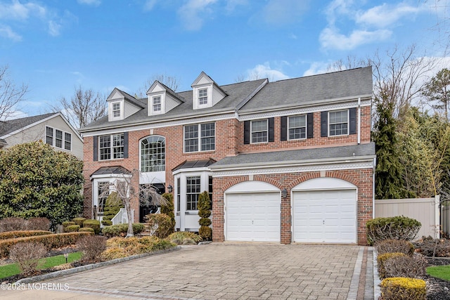 view of front of property featuring fence, decorative driveway, and brick siding