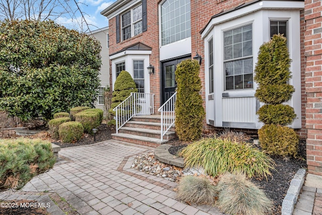 doorway to property featuring brick siding