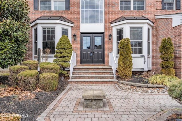 entrance to property featuring french doors and brick siding