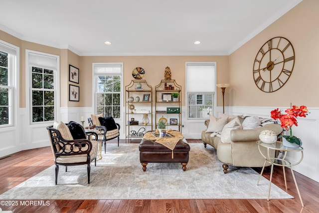 living room with recessed lighting, ornamental molding, hardwood / wood-style floors, and wainscoting