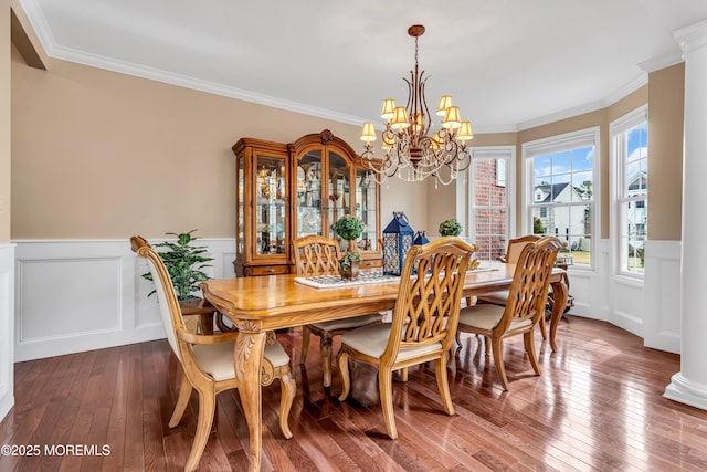 dining room featuring hardwood / wood-style flooring, crown molding, and wainscoting