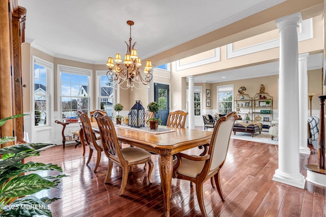 dining room with ornamental molding, wood-type flooring, and decorative columns