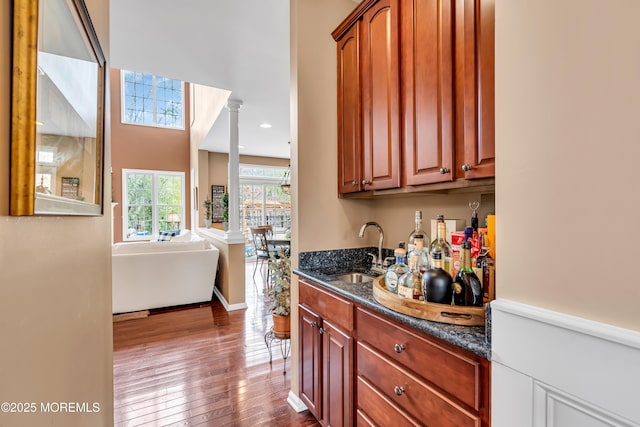 bar featuring dark wood-type flooring, a sink, and recessed lighting