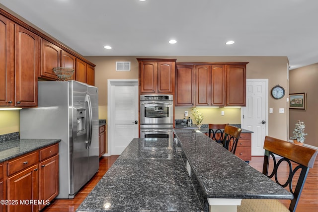 kitchen with dark wood-style floors, appliances with stainless steel finishes, visible vents, and recessed lighting