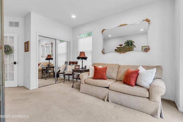 carpeted living area featuring recessed lighting, visible vents, and baseboards