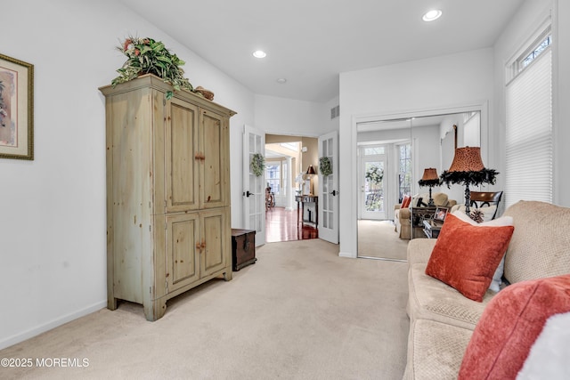 living room featuring light carpet, baseboards, visible vents, and recessed lighting