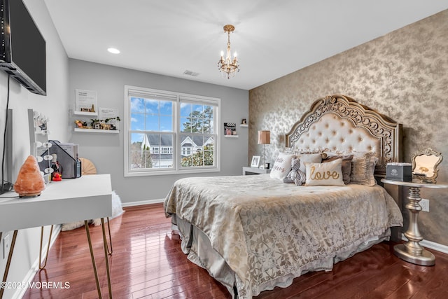 bedroom with wallpapered walls, baseboards, visible vents, wood-type flooring, and an accent wall