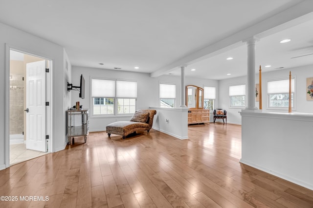 unfurnished room with recessed lighting, decorative columns, and light wood-style floors