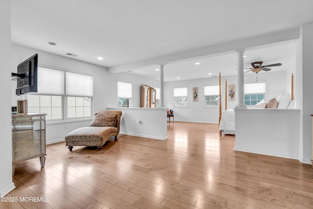 sitting room with visible vents, light wood-style flooring, decorative columns, and recessed lighting