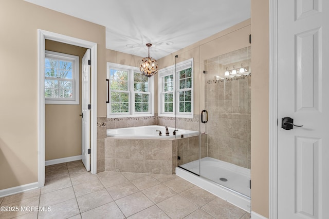 bathroom featuring baseboards, a bath, tile patterned floors, a stall shower, and an inviting chandelier