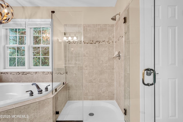 bathroom with a shower stall and a bath