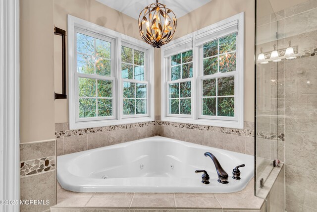 full bathroom with a whirlpool tub, a wealth of natural light, and an inviting chandelier