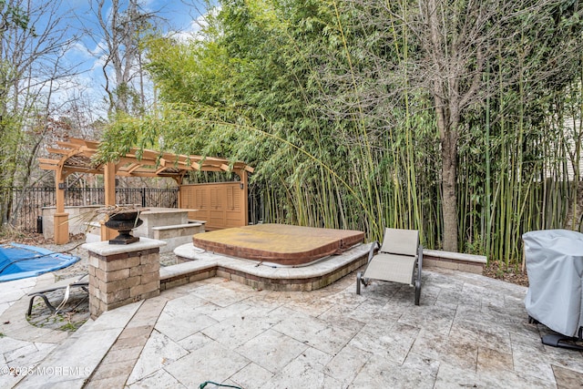 view of patio featuring a covered hot tub, fence, grilling area, and a pergola