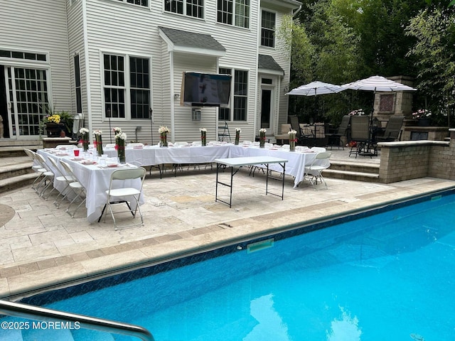 outdoor pool with a patio area and outdoor dining space