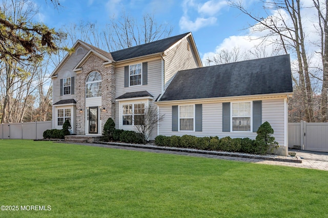 traditional home featuring a shingled roof, a gate, fence, and a front yard