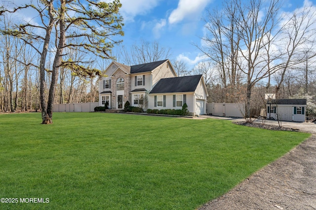 view of front of house with a garage, driveway, fence, and a front yard