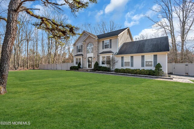 view of front of home featuring a gate, fence, and a front lawn