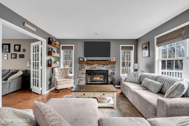 living room featuring a fireplace, wood finished floors, and baseboards