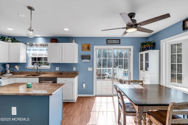 kitchen with dishwasher, pendant lighting, a sink, and white cabinets