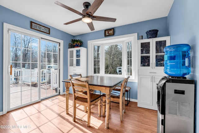 dining room with light wood-type flooring, ceiling fan, and baseboards