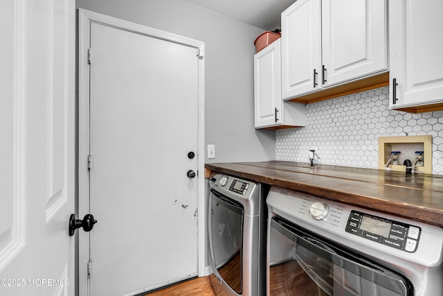 laundry room featuring washing machine and clothes dryer and cabinet space