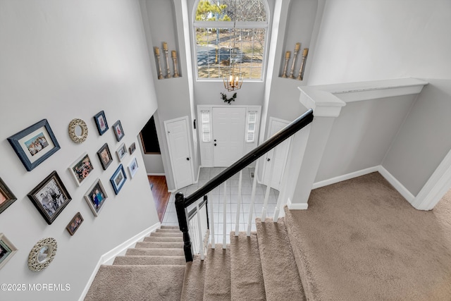 staircase featuring carpet, tile patterned flooring, and baseboards