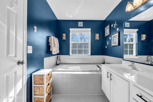 bathroom featuring tile patterned flooring, a garden tub, plenty of natural light, and vanity