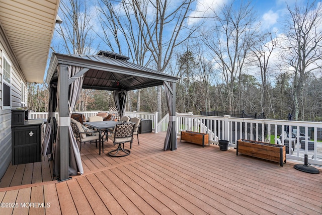 wooden deck with outdoor dining area and a gazebo