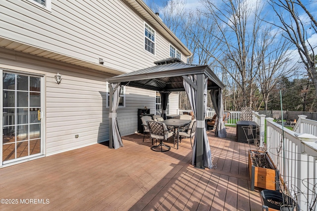 deck with a gazebo, fence, and outdoor dining space