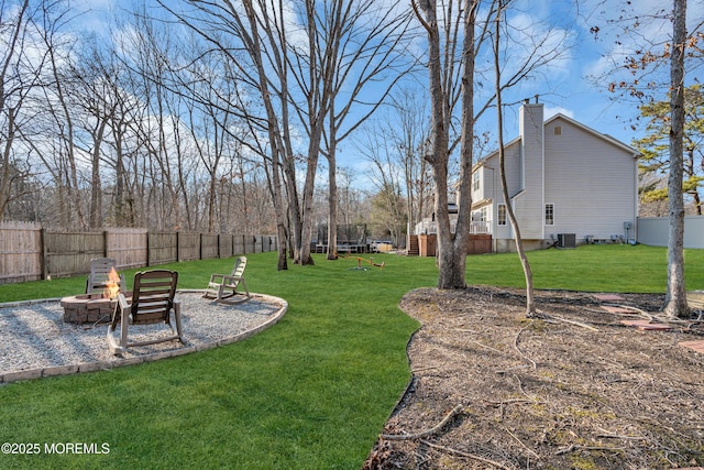 view of yard with an outdoor fire pit, central AC, and a fenced backyard