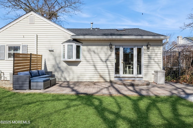 rear view of property featuring a shingled roof, fence, an outdoor living space, a lawn, and a patio area