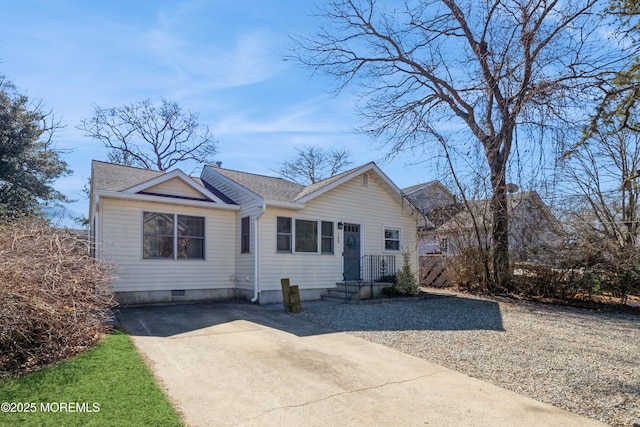 view of front of house with roof with shingles and driveway