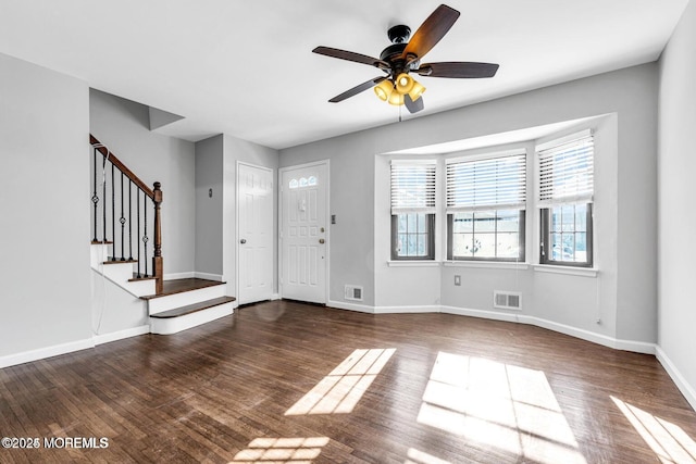 entryway with stairs, wood finished floors, visible vents, and baseboards