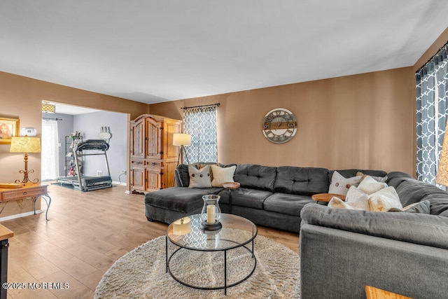 living area featuring light wood finished floors and baseboards