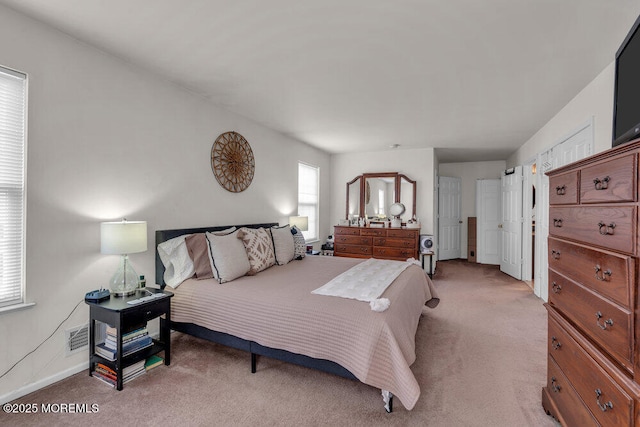 bedroom with baseboards and light colored carpet