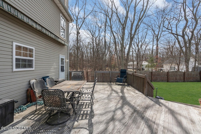 deck featuring a yard, outdoor dining area, and fence