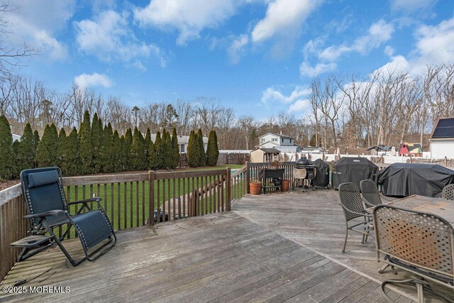 wooden terrace featuring a lawn and area for grilling