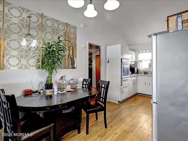 dining area with lofted ceiling and light wood finished floors