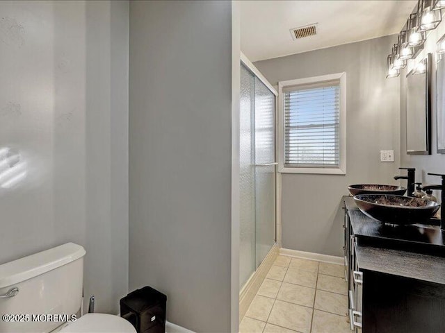 full bath with a stall shower, visible vents, toilet, tile patterned floors, and a sink