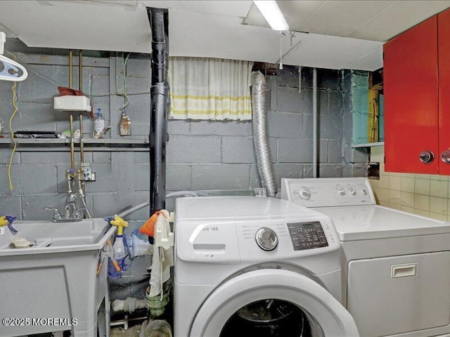 washroom with laundry area, a sink, and washer and clothes dryer