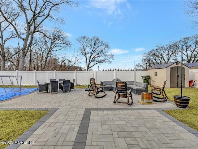 view of patio featuring an outbuilding, a shed, a fenced backyard, and an outdoor living space