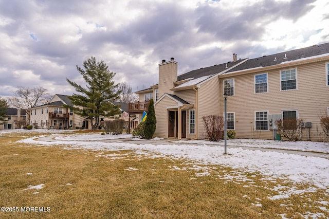 snow covered property with a chimney